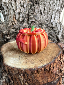 Metallic orange pumpkin-shaped object on a wooden surface